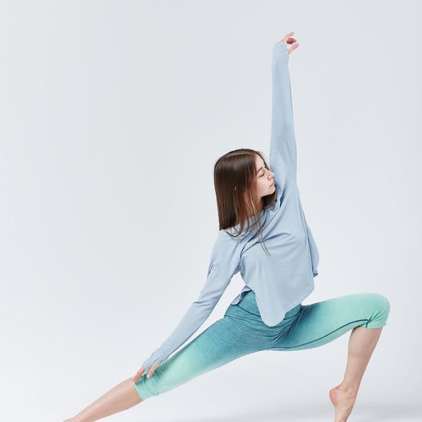 Woman in a graceful stretching pose, representing tranquility and flexibility.